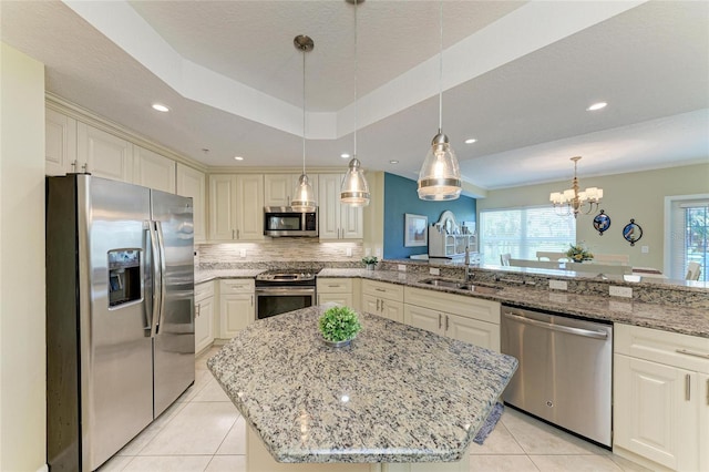 7820 34th Ave W Unit 102, Bradenton, FL 34209 - kitchen with stainless steel appliances, light tile patterned flooring, light stone countertops, a chandelier, and tasteful backsplash