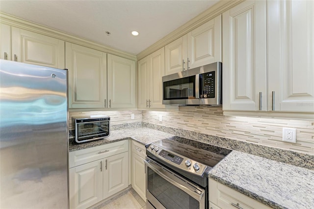 7820 34th Ave W Unit 102, Bradenton, FL 34209 - kitchen featuring appliances with stainless steel finishes, cream cabinetry, and tasteful backsplash