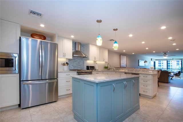 5750 Midnight Pass Rd Unit 203, Sarasota, FL 34242 - kitchen featuring stainless steel appliances, wall chimney range hood, a peninsula, white cabinets, and a kitchen island