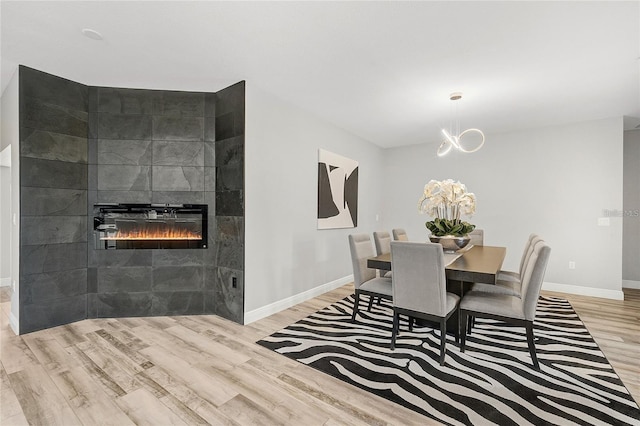 2912 51st St E, Bradenton, FL 34208 - dining space with wood finished floors, a tiled fireplace, and a chandelier