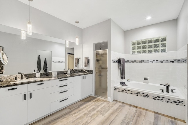 2912 51st St E, Bradenton, FL 34208 - full bathroom with a stall shower, double vanity, a bath, and wood finished floors