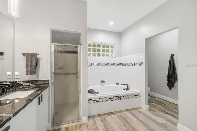 2912 51st St E, Bradenton, FL 34208 - bathroom featuring vanity, a shower stall, a garden tub, and wood finished floors