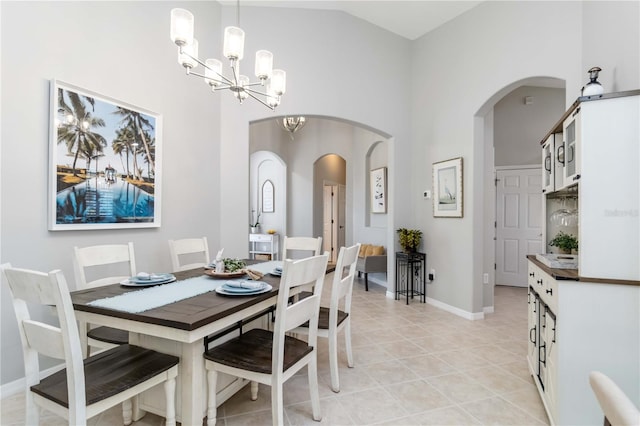 7343 Birds Eye Ter, Bradenton, FL 34203 - dining space featuring a chandelier, high vaulted ceiling, light tile patterned flooring, baseboards, and arched walkways