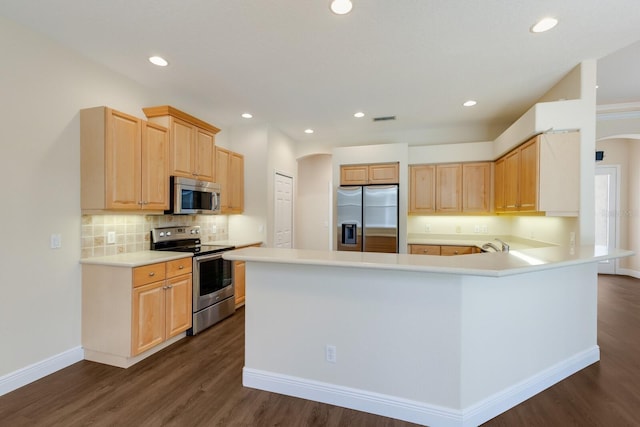 4998 Cedar Oak Way, Sarasota, FL 34233 - kitchen with stainless steel appliances, arched walkways, dark wood-style flooring, backsplash, and recessed lighting