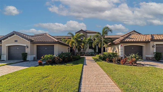 5604 Palmer Cir Unit 103, Bradenton, FL 34211 - view of front of house with stucco siding, a tile roof, a front yard, and an attached garage