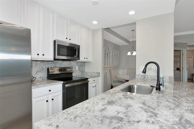 5604 Palmer Cir Unit 103, Bradenton, FL 34211 - kitchen with appliances with stainless steel finishes, light stone countertops, white cabinets, ornamental molding, and recessed lighting