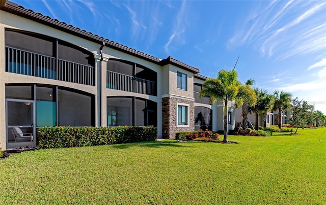 5604 Palmer Cir Unit 103, Bradenton, FL 34211 - back of house featuring stucco siding, a yard, a tile roof, and stone siding