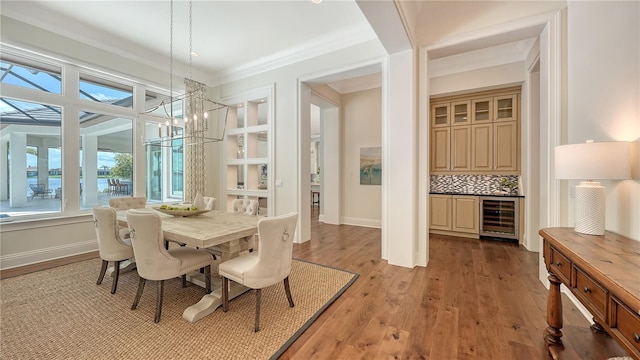 14665 Como Cir, Lakewood Ranch, FL 34202 - dining room featuring wine cooler, a chandelier, light wood-style floors, a dry bar, and crown molding