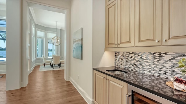 14665 Como Cir, Lakewood Ranch, FL 34202 - indoor wet bar with decorative backsplash, light wood-type flooring, beverage cooler, crown molding, and a chandelier