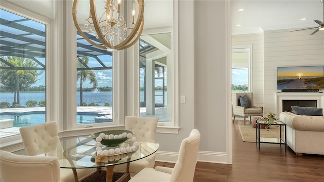 14665 Como Cir, Lakewood Ranch, FL 34202 - dining area featuring a water view, dark wood finished floors, a chandelier, crown molding, and recessed lighting