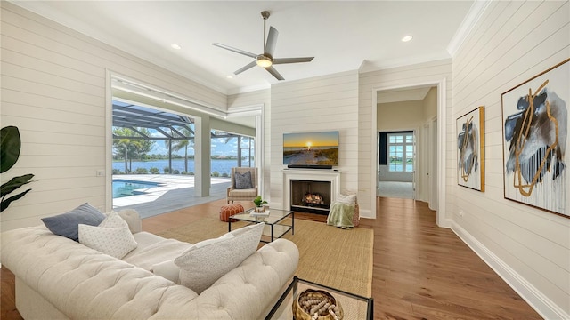 14665 Como Cir, Lakewood Ranch, FL 34202 - living room featuring wood walls, crown molding, a ceiling fan, wood finished floors, and a sunroom
