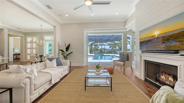 14665 Como Cir, Lakewood Ranch, FL 34202 - living room featuring crown molding, ceiling fan, plenty of natural light, a sunroom, and a chandelier