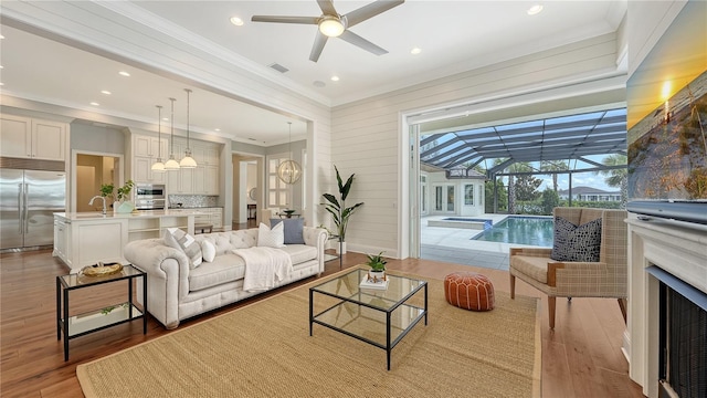 14665 Como Cir, Lakewood Ranch, FL 34202 - living room with a sunroom, a ceiling fan, crown molding, wood finished floors, and recessed lighting