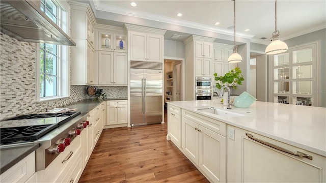14665 Como Cir, Lakewood Ranch, FL 34202 - kitchen with stainless steel appliances, custom range hood, hanging light fixtures, backsplash, and ornamental molding