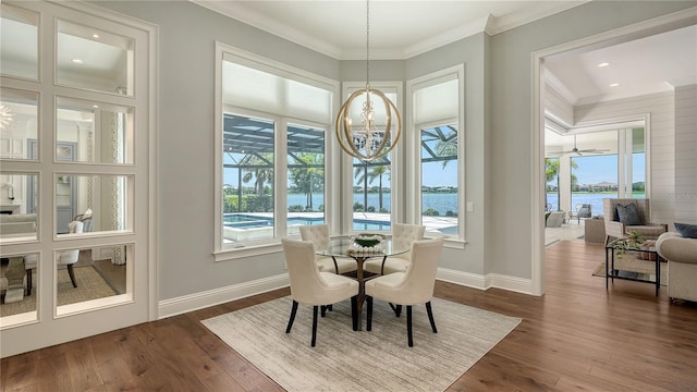 14665 Como Cir, Lakewood Ranch, FL 34202 - dining area with crown molding, dark wood-type flooring, recessed lighting, a water view, and a chandelier