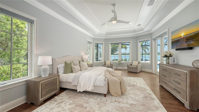 14665 Como Cir, Lakewood Ranch, FL 34202 - bedroom featuring multiple windows, a tray ceiling, access to outside, dark wood-style flooring, and ornamental molding