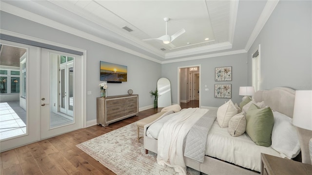 14665 Como Cir, Lakewood Ranch, FL 34202 - bedroom featuring a tray ceiling, access to outside, wood finished floors, ornamental molding, and french doors