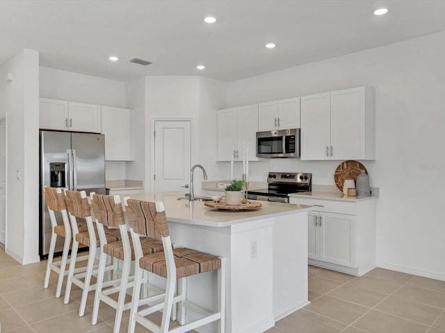 8733 Winter Breeze Way, Sarasota, FL 34241 - kitchen featuring appliances with stainless steel finishes, a sink, light tile patterned flooring, white cabinets, and recessed lighting