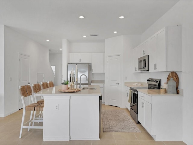 8733 Winter Breeze Way, Sarasota, FL 34241 - kitchen featuring appliances with stainless steel finishes, a sink, a breakfast bar, an island with sink, and white cabinetry