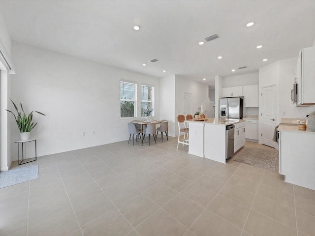 8733 Winter Breeze Way, Sarasota, FL 34241 - kitchen with appliances with stainless steel finishes, light countertops, a kitchen island with sink, white cabinets, and recessed lighting