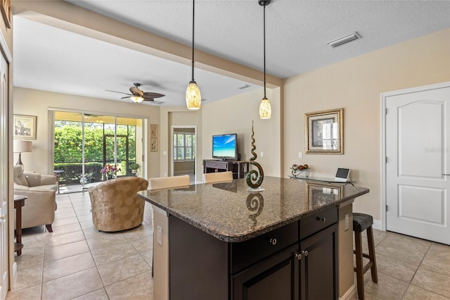 2070 Crystal Lake Trl, Bradenton, FL 34211 - kitchen with open floor plan, light tile patterned floors, a kitchen breakfast bar, hanging light fixtures, and a kitchen island