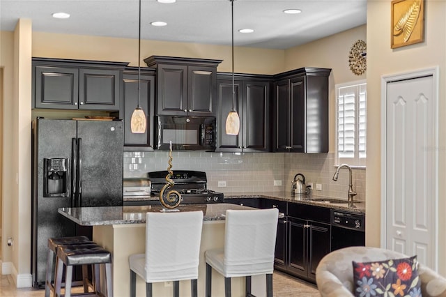 2070 Crystal Lake Trl, Bradenton, FL 34211 - kitchen featuring black appliances, dark stone countertops, decorative backsplash, a kitchen island, and a kitchen bar