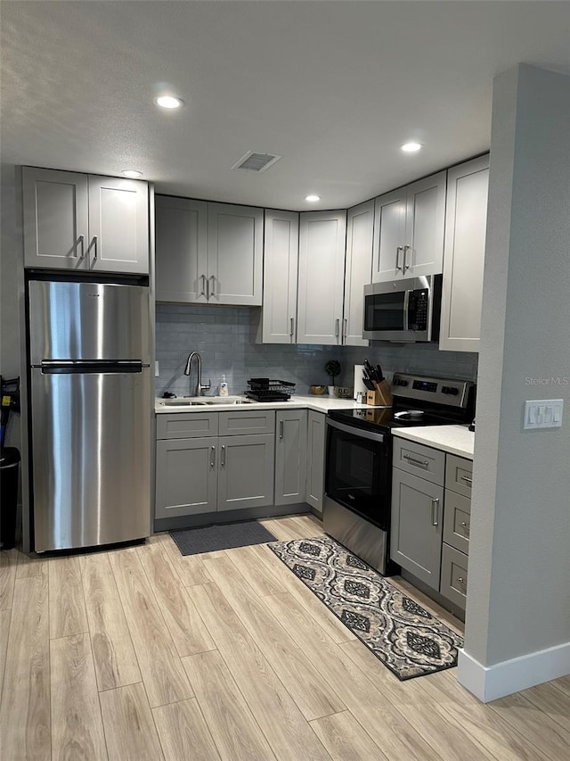 1840 3rd Ave E, Bradenton, FL 34208 - kitchen with appliances with stainless steel finishes, gray cabinets, light wood-style flooring, light countertops, and recessed lighting