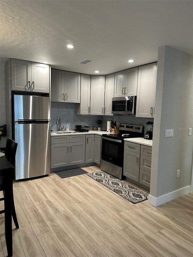 1840 3rd Ave E, Bradenton, FL 34208 - kitchen featuring stainless steel appliances, gray cabinets, light wood-type flooring, and recessed lighting