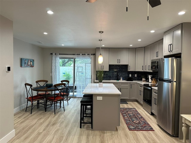 1840 3rd Ave E, Bradenton, FL 34208 - kitchen featuring stainless steel appliances, gray cabinetry, light wood-style floors, light countertops, and decorative backsplash