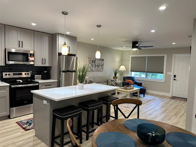 1840 3rd Ave E, Bradenton, FL 34208 - kitchen with appliances with stainless steel finishes, gray cabinets, open floor plan, light countertops, and a breakfast bar area