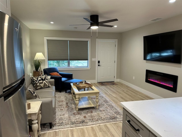 1840 3rd Ave E, Bradenton, FL 34208 - living area featuring light wood-type flooring, ceiling fan, recessed lighting, and a glass covered fireplace