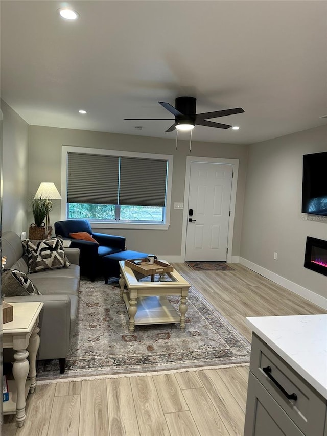 1840 3rd Ave E, Bradenton, FL 34208 - living room featuring light wood-style flooring, a ceiling fan, a glass covered fireplace, and recessed lighting