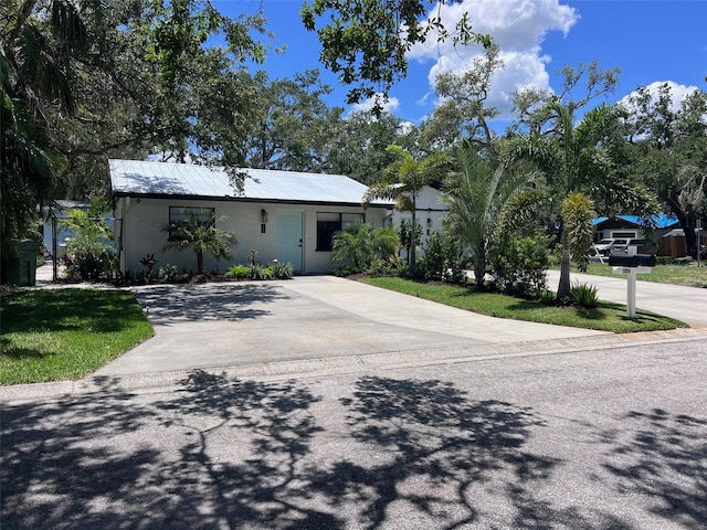 1840 3rd Ave E, Bradenton, FL 34208 - view of front of house featuring concrete driveway, stucco siding, and a metal roof