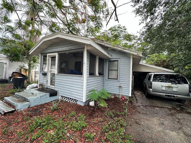 2230 50th Ave N, Saint Petersburg, FL 33714 - view of side of home with a sunroom, an attached carport, driveway, and crawl space