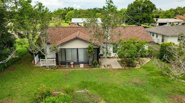 5213 20th Street Ct E, Bradenton, FL 34203 - rear view of house featuring a sunroom, a lawn, and roof with shingles