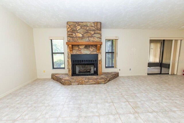 5213 20th Street Ct E, Bradenton, FL 34203 - unfurnished living room featuring a textured ceiling, a fireplace, and tile patterned floors