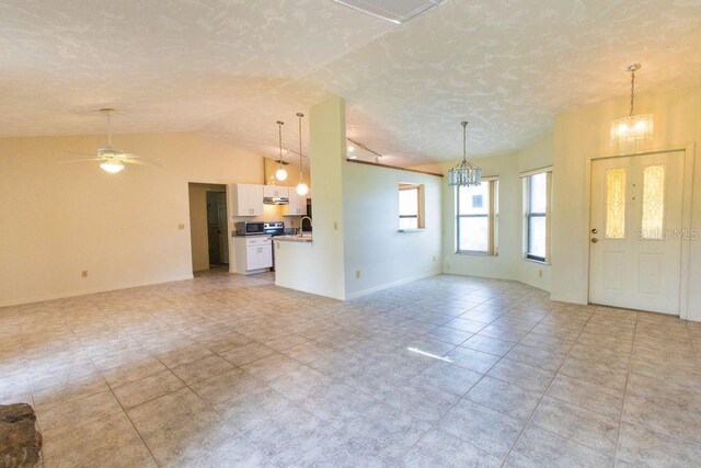 5213 20th Street Ct E, Bradenton, FL 34203 - unfurnished living room featuring a chandelier, lofted ceiling, a textured ceiling, and ceiling fan