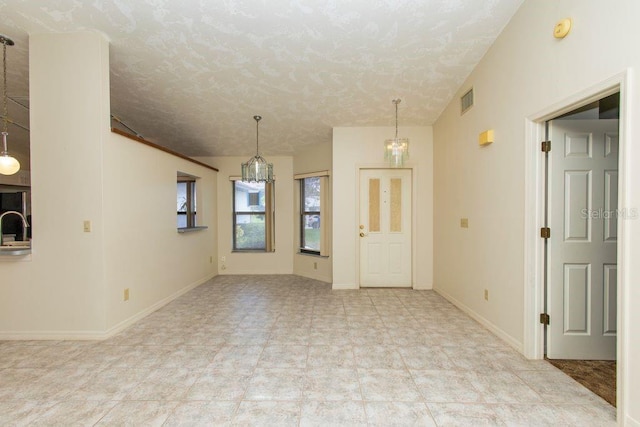 5213 20th Street Ct E, Bradenton, FL 34203 - spare room with a smoke detector, a textured ceiling, and a chandelier