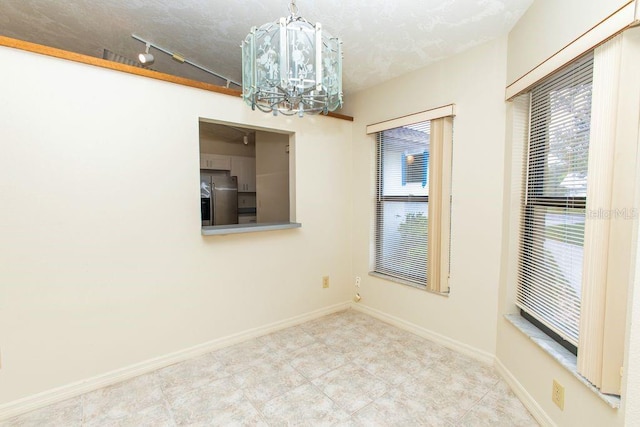 5213 20th Street Ct E, Bradenton, FL 34203 - tiled empty room with a chandelier and track lighting