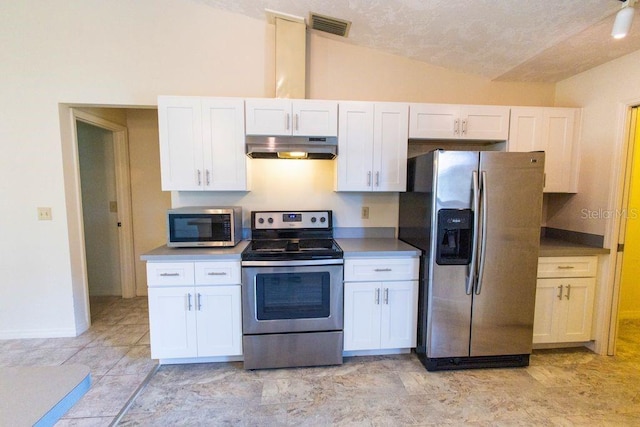 5213 20th Street Ct E, Bradenton, FL 34203 - kitchen with appliances with stainless steel finishes, under cabinet range hood, vaulted ceiling, white cabinetry, and a textured ceiling