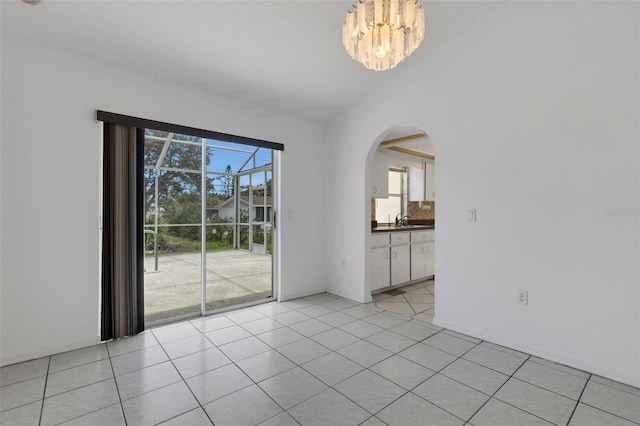 1026 Graham Rd, Venice, FL 34293 - empty room with arched walkways, light tile patterned floors, and a chandelier
