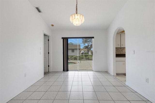 1026 Graham Rd, Venice, FL 34293 - unfurnished dining area with a chandelier, arched walkways, and light tile patterned flooring