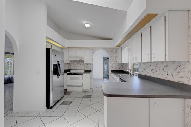 1026 Graham Rd, Venice, FL 34293 - kitchen featuring stainless steel fridge, white range with electric cooktop, under cabinet range hood, arched walkways, and lofted ceiling