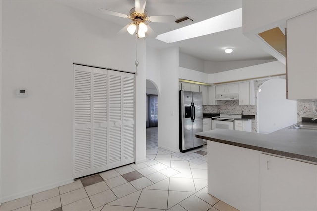 1026 Graham Rd, Venice, FL 34293 - kitchen with stainless steel refrigerator with ice dispenser, electric stove, arched walkways, under cabinet range hood, and dark countertops