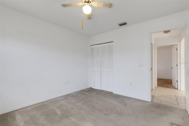 1026 Graham Rd, Venice, FL 34293 - unfurnished bedroom featuring carpet, a closet, a ceiling fan, and tile patterned flooring