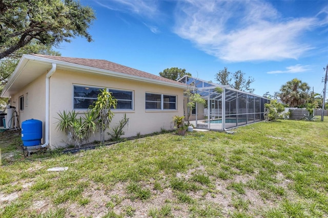 1026 Graham Rd, Venice, FL 34293 - back of property featuring stucco siding, a lawn, and a lanai