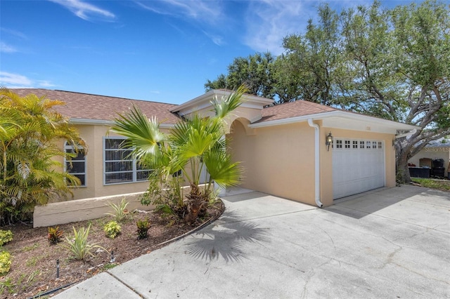 1026 Graham Rd, Venice, FL 34293 - view of front of house with stucco siding, concrete driveway, a garage, and roof with shingles