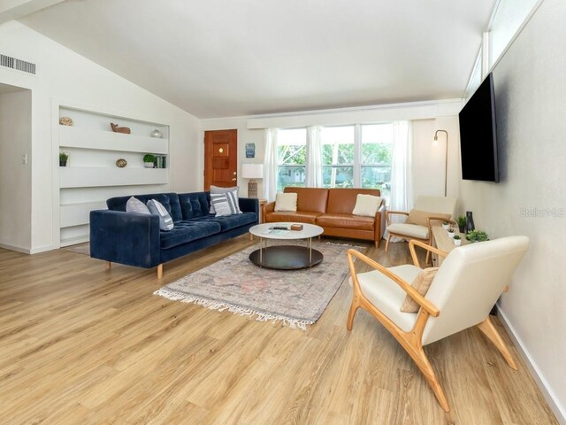 2933 Michigan St, Sarasota, FL 34237 - living room featuring built in shelves, light wood-style floors, and lofted ceiling