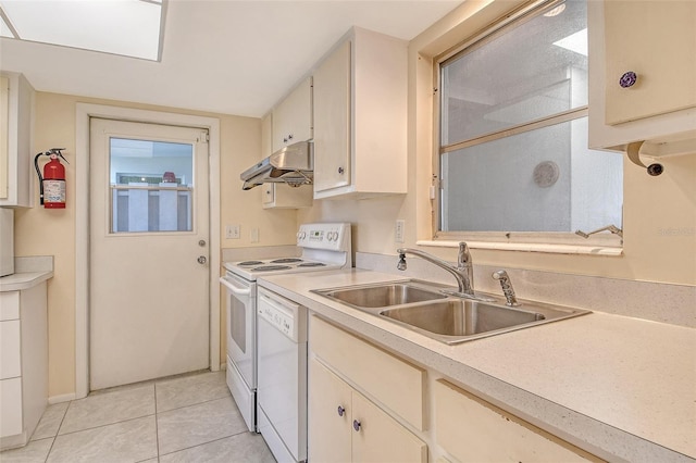 3276 Westford Ln, Sarasota, FL 34231 - kitchen with white appliances, under cabinet range hood, light countertops, and light tile patterned floors