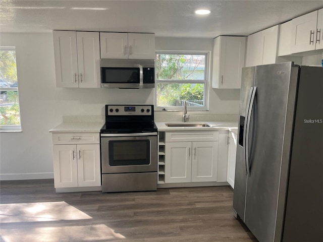 4740 Garcia Ave, Sarasota, FL 34233 - kitchen featuring appliances with stainless steel finishes, white cabinetry, light countertops, dark wood-style flooring, and recessed lighting